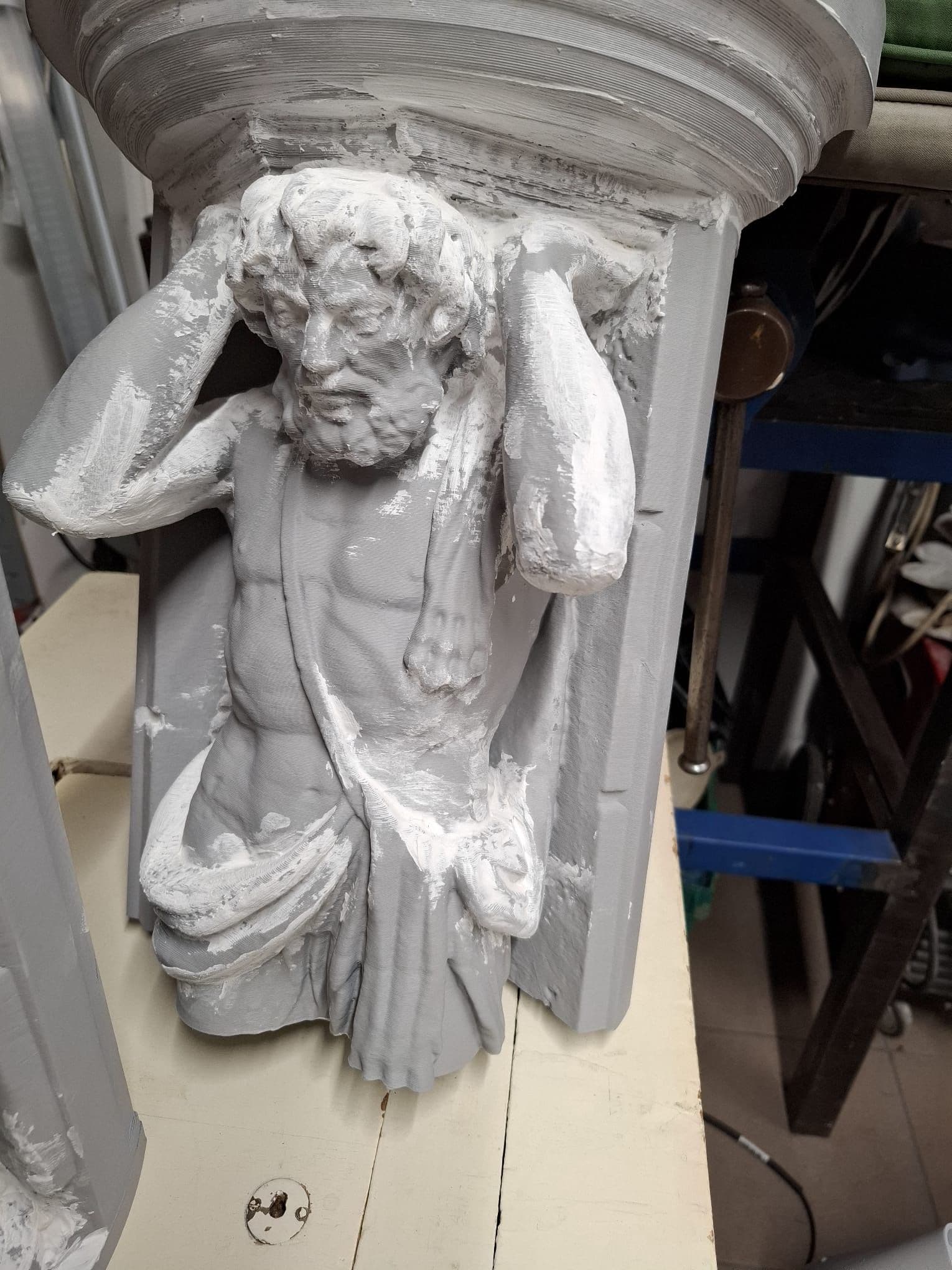 3D tlačená replika Corgoňa, biela figúra muža podopierajúceho stĺp, vo fáze povrchovej úpravy